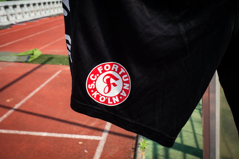 Nahaufnahme des Fortuna Köln Logos auf der Trainingshose.