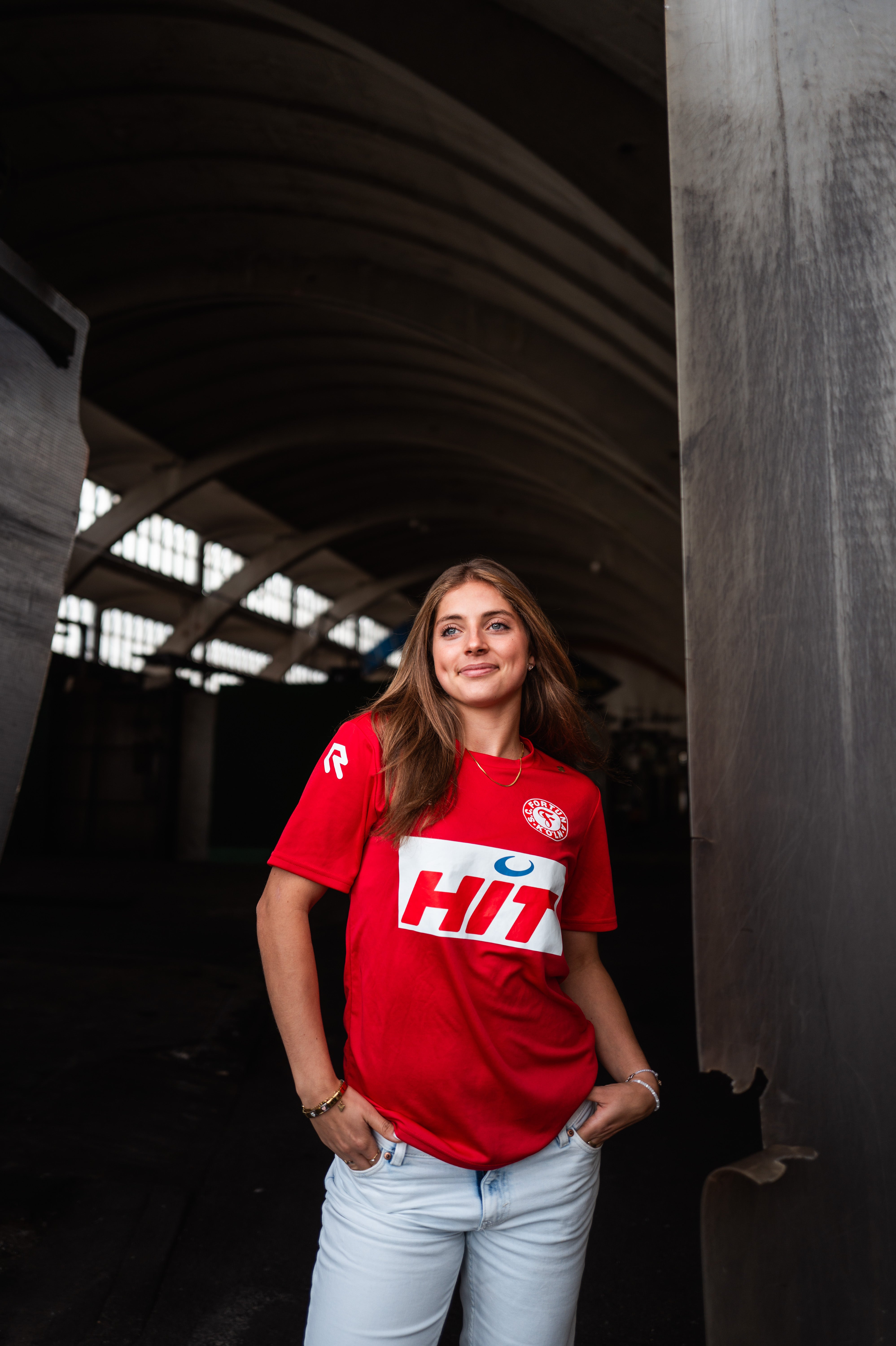 Eine Dame trägt ein kurzarm-Trainingsshirt von Fortuna Köln.