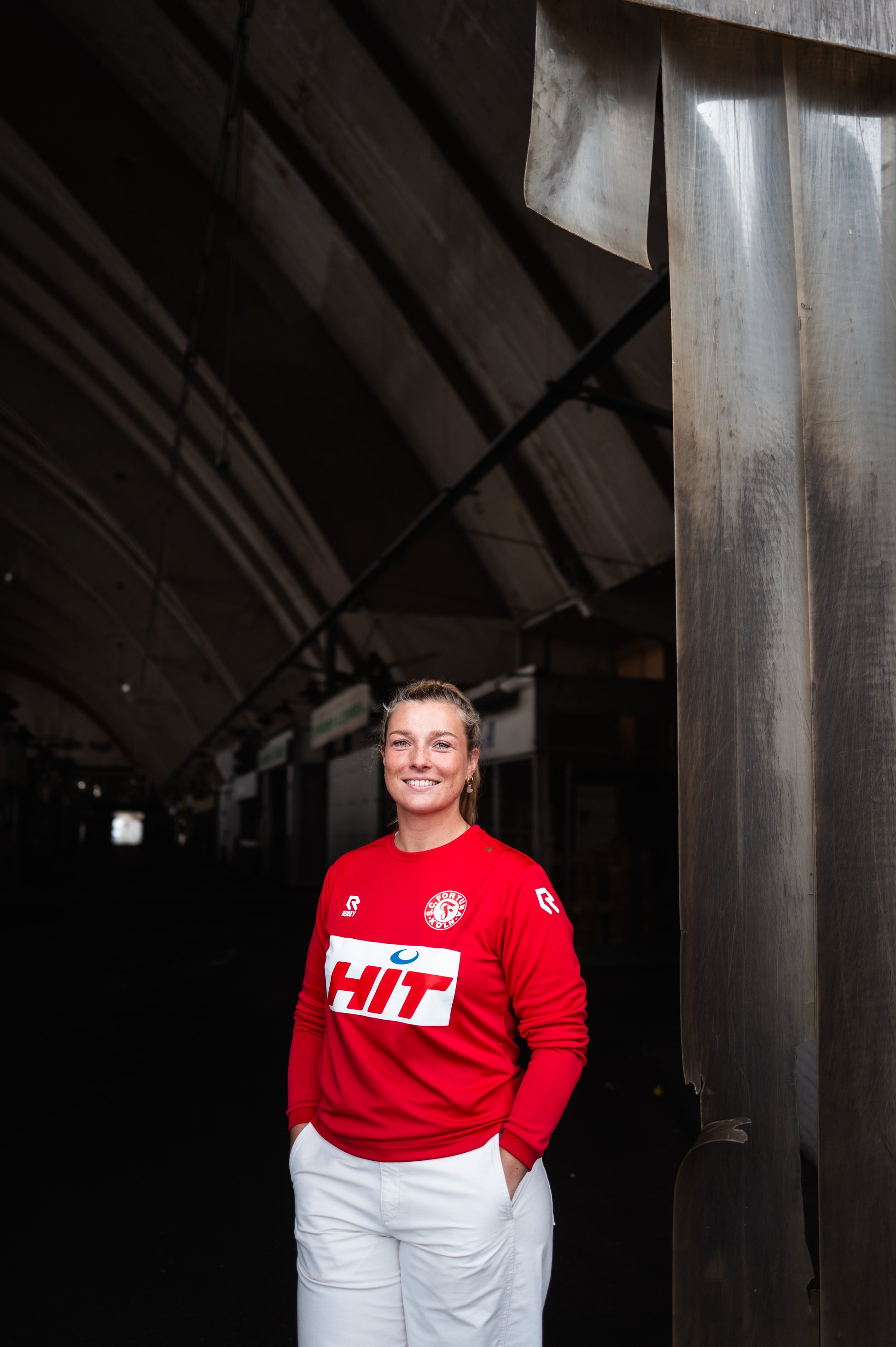 Eine Frau trägt das Fortuna Köln langarm-Trainingsshirt.
