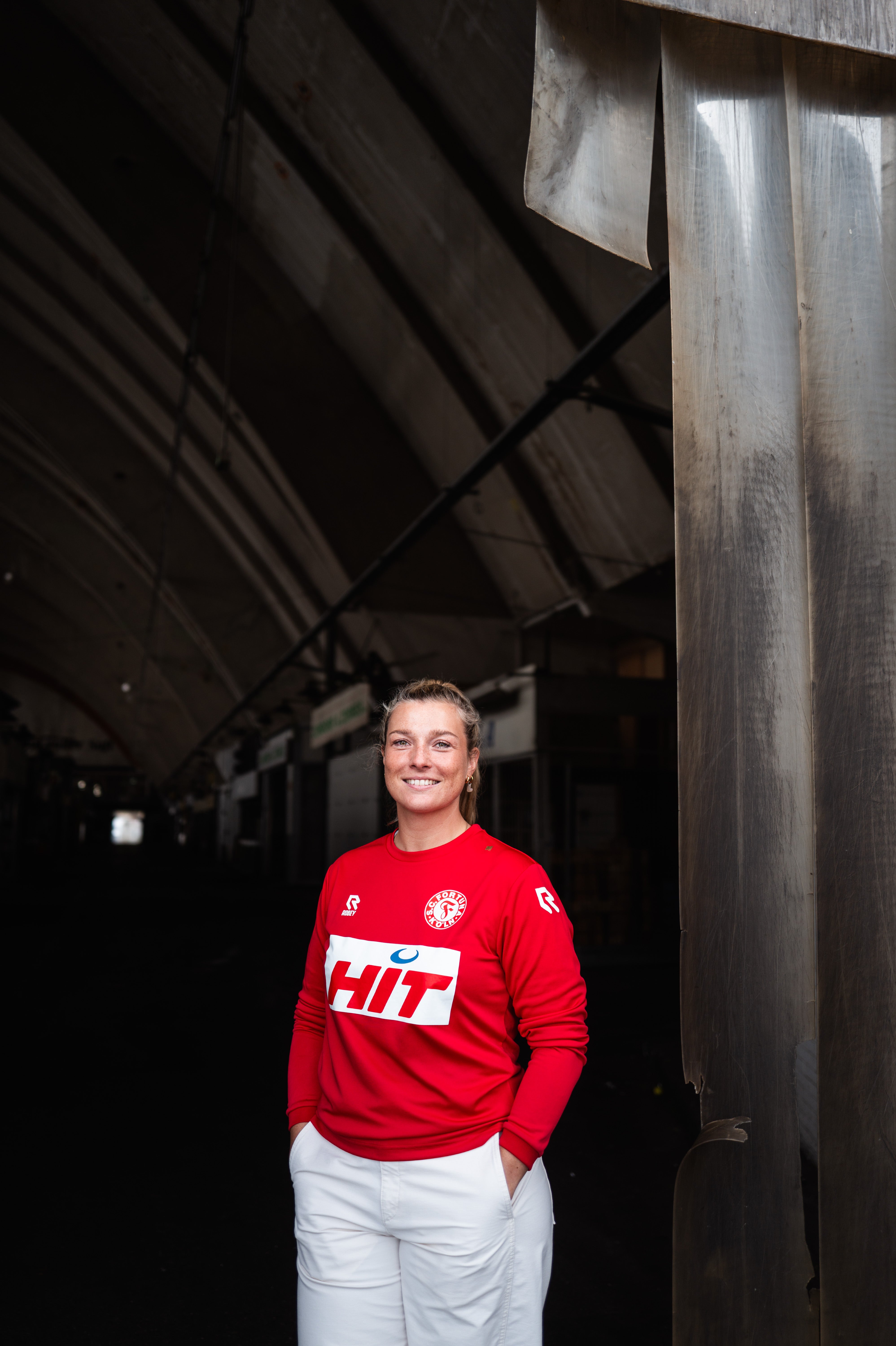 Eine Frau trägt das Fortuna Köln langarm-Trainingsshirt.