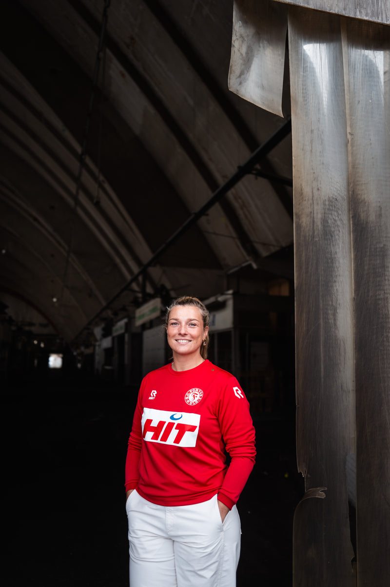 Eine Frau trägt das Fortuna Köln langarm-Trainingsshirt.